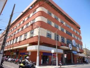 パルナイバにあるDelta Prime HOTELの建物前に停められた二輪車の男