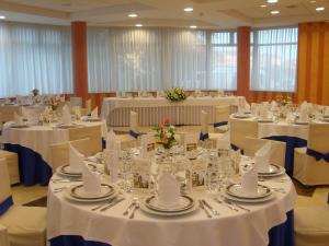 a room filled with tables with white tablecloths and chairs at Hotel Escuela San Cristóbal in La Cistérniga