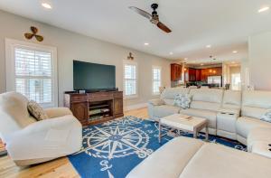 a living room with white furniture and a flat screen tv at Carolina Beach North by Carolina Beach Realty in Carolina Beach