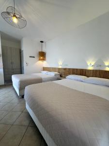a bedroom with two beds and a light fixture at Tsimiklis Apartments in Finikounta