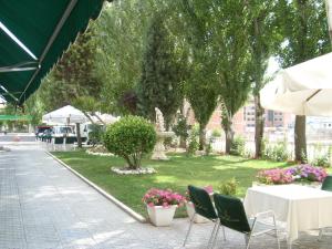 patio con tavolo, sedie e parco di Hotel Escuela San Cristobal a La Cistérniga
