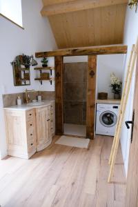 a bathroom with a sink and a washing machine at Maison de vacances avec SPA in Martinvast