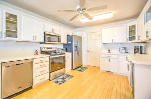 a kitchen with white cabinets and a ceiling fan at Casablanca by Carolina Beach Realty in Kure Beach +13 photos