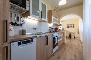 a kitchen with white appliances and an open hallway at Sunny Beach in Zánka