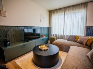 デ・パンネにあるVillage Normandieのソファとテーブルのあるリビングルーム