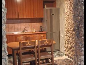 a kitchen with a wooden table and a refrigerator at RETRO house in Korçë +4 photos
