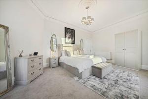 1 dormitorio con cama, espejo y tocador en Large Terraced Home with Parking, en Glasgow