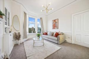 una sala de estar con un sofá y una mesa en Large Terraced Home with Parking, en Glasgow