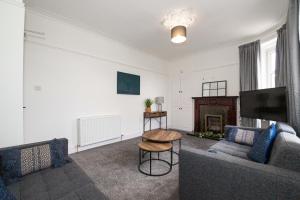 Una sala de estar con un sofá y un televisor. en Carnoustie Residence - SJA Stays - 3 Bed Apartment, en Carnoustie