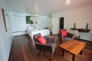 a bedroom with a bed and two chairs and a table at Casa da Ilha & SPA in Abraão
