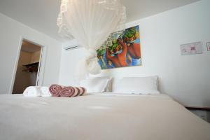 a bedroom with a white bed with towels on it at Casa da Ilha & SPA in Abraão