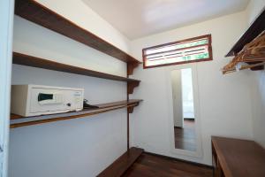a kitchen with a microwave on a wall with a window at Casa da Ilha & SPA in Abraão