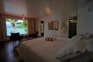a bedroom with a large bed with a view of the ocean at Casa da Ilha & SPA in Abraão
