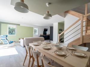 a dining room with a wooden table and chairs at Maison neuve climatisée, 8 pers, proche plages, surf, Wi-Fi, terrasse, parking, ménage inclus - FR-1-319-526 in Biscarrosse