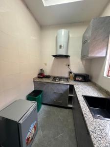 a small kitchen with a stove and a refrigerator at Aqua black studio room in Lagos