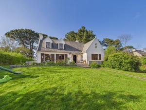 a person throwing a frisbee in front of a house at Maison pour 10 avec grand jardin à 250m de la mer in Louannec