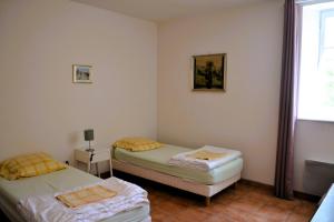 two twin beds in a room with a window at Maison Le Landais in Grandcamp-Maisy
