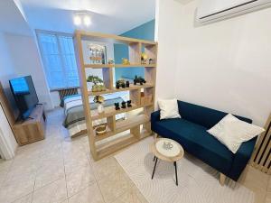 a living room with a blue couch and a television at Studio Centre Ville Tarbes in Tarbes