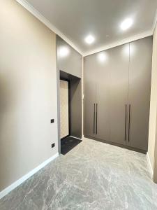 an empty room with white cabinets and marble floors at Красивая евродвушка на Левом берегу Астаны, район ЭКСПО in Astana