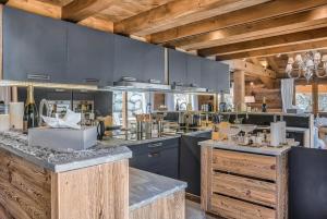 eine große Küche mit blauen Schränken und Holzdecken in der Unterkunft JAMES TAMG24 - Stunning ski in ski out luxury chalet with indoor pool & cinema in Praz-sur-Arly
