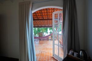 an open door to a patio with a brick floor at Casa da Ilha & SPA in Abraão