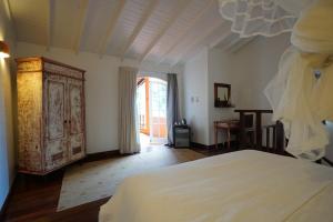 a bedroom with a bed and an open door at Casa da Ilha & SPA in Abraão