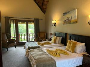a bedroom with two beds with towels on them at Koro Lodge in Modimolle +16 photos
