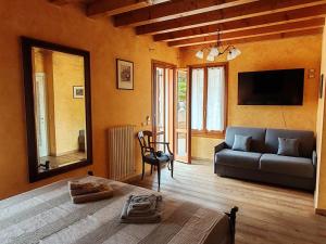 a living room with a couch and a tv at Casa dei Cedri in Sommacampagna