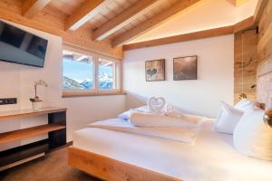 图克斯Chalet´s Alpenjuwel的卧室配有白色的床,墙上配有电视