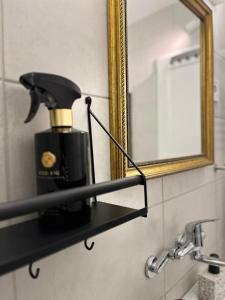 Un dispensador de jabón negro en un estante en un baño. en Wert House, en Novi Sad