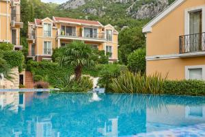 a swimming pool in front of a building at Boka Kotorska Apartmani in Gornji Orahovac