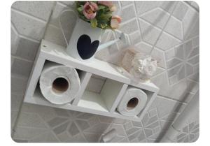 a white shelf with a vase and two rolls of toilet paper at Apto na Siqueira Campos, centro in Santarém