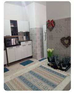 a kitchen with white cabinets and blue and white tiles at Apto na Siqueira Campos, centro in Santarém