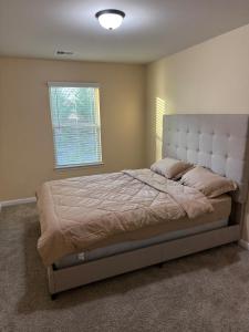 - une chambre avec un grand lit et une tête de lit blanche dans l'établissement 3bed townhouse in McDonough GA, à McDonough