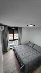 une chambre avec un lit et une grande fenêtre dans l'établissement Betania Plaza Premium, Piso17 - BY INMOVE TEMPORARIOS, à Córdoba