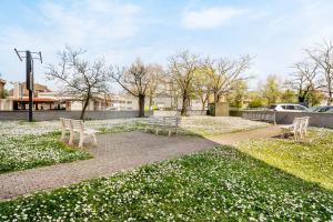 a park with two benches and white flowers at Stilvolles City-Apartment mit Balkon & Parkplatz, Nähe Frankfurt in Hanau am Main