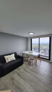 un salon avec un canapé noir et une table dans l'établissement Betania Plaza Premium, Piso17 - BY INMOVE TEMPORARIOS, à Córdoba