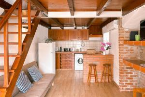 a kitchen with a white refrigerator and wooden cabinets at Quinta da Fonte - Casa da Charrete in Caldas da Rainha