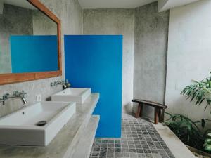 a bathroom with two sinks and a blue wall at Villa TELU in Canggu +35 photos