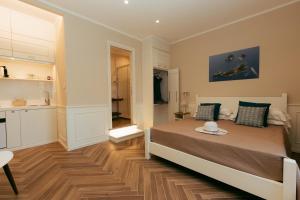 Un dormitorio con una cama grande y una cocina. en Cyrus&Janus flats - De Vivo Realty, en Piano di Sorrento