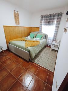 ein Bett in einem Zimmer mit Fliesenboden in der Unterkunft casa dos Ferreira no Douro in Ucanha + 19 Fotos