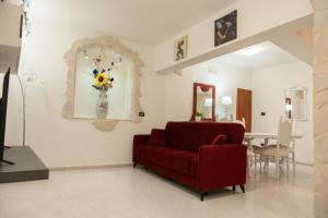 a living room with a red couch and a table at 5 stelle Dimora storica in Valle D'Itria con WIFI in Turi