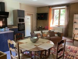 a kitchen and living room with a table and chairs at La Buchille in Château-Chervix