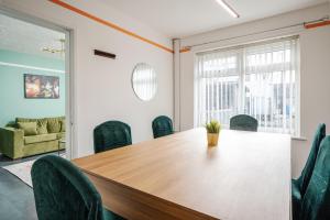una sala de conferencias con una mesa y sillas de madera en The Jade - Pool Table - Man Utd - City Centre - 4bd, en Mánchester 36 fotos más