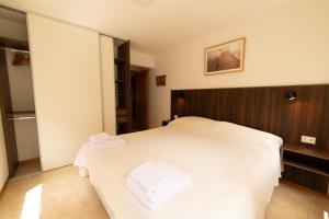 a bedroom with a white bed with a wooden headboard at Ventanas al Sur - Espacio Bandurrias - in San Martín de los Andes