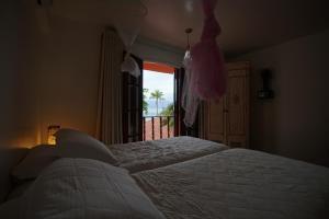 a bedroom with a large bed and a window at Casa da Ilha & SPA in Abraão