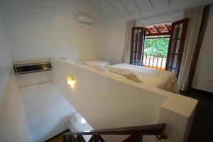 a white room with two beds and a window at Casa da Ilha & SPA in Abraão
