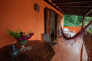 a table with a vase of flowers on a balcony at Casa da Ilha & SPA in Abraão