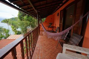 a balcony with a hammock and a table and chairs at Casa da Ilha & SPA in Abraão