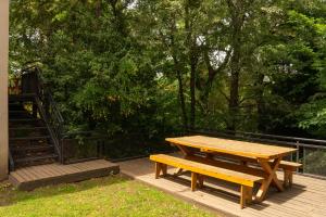 a wooden picnic table and bench on a deck at Ventanas al Sur - Espacio Bandurrias - in San Martín de los Andes